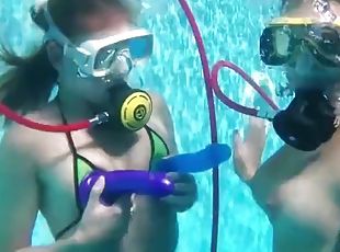 Two hot lesbians playing with dildos in the pool