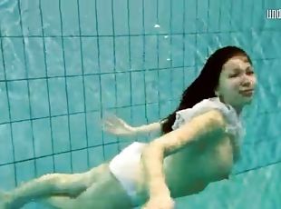 Girl in white panties swims in pool