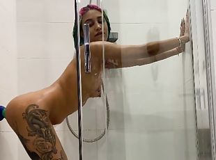 Tattooed girl rides a toy in the shower